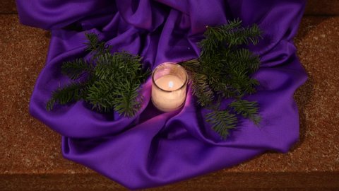 Funeral floor decoration with burning candles and purple cloth in the church of Vohrenbach, Germany.