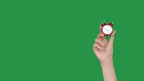 Hurry up. Time reminder. Last minute offer. Female hand shaking vintage miniature red alarm clock isolated on green chroma key empty space advertising background set of 2.