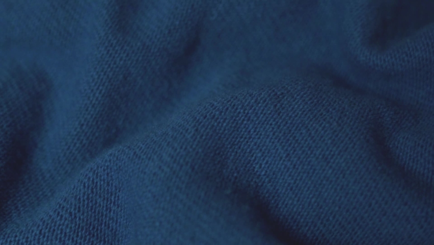 Woolen Knitted Dark Blue Fabric, Detailed Texture, Close up, Macro. Cozy Wool Blanket, Bedspread, Textile, Thin Yarn, Knit, Warm Sweater. Dark Blue Fabric Background. Factory Shop Woolen Products. Royalty-Free Stock Footage #1088778921