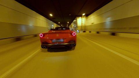 Speed flight follow movement FPV drone aerial view dark tunnel with fast driving red sport car. Dangerous riding automobile vehicle blurred lights urban travel transportation underground highway Vídeo Stock