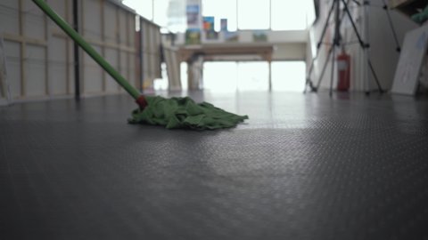 Man cleaning linoleum floor using mop Medium Shot