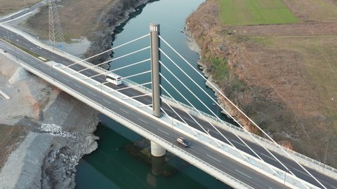 Cable-stayed bridge (harp design) with a single pylon (tower) over Moraca river near Podgorica Montenegro. Aerial drone view of the lines (cables) running from central column to the deck.