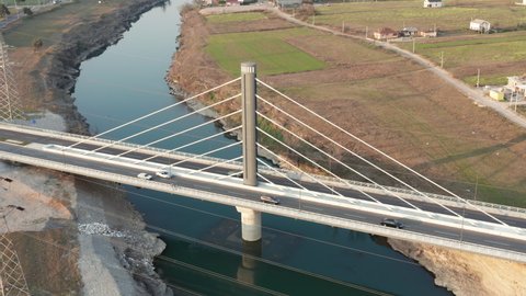 Cable-stayed bridge (harp design) with a single pylon (tower) over Moraca river near Podgorica Montenegro. Aerial drone view of the lines (cables) running from central column to the deck.