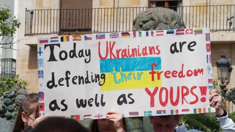 VALENCIA, SPAIN - MARCH 27, 2022: Protest against war in Ukraine. Protest against Russia's invasion of Ukraine. Many young people came to the rally. The protesters are holding a banner with the image