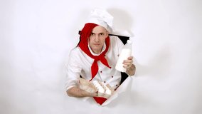 Man with red dreadlocks holds it in his hand chicken eggs and milk. Confident young cook in white apron and red tie holding chicken eggs and a bottle of milk, peeking through ripped paper background - Powered by Shutterstock - Get 15% off with code: PIKWIZARD15
