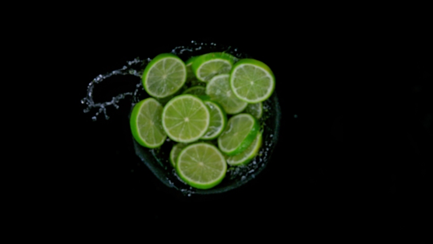 Super slow motion shot of rotating exploded lime slices with splashing water on black at 1000fps. Royalty-Free Stock Footage #1088787701