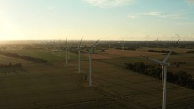 Aerial view of windmills rotating under the force of the wind and generating renewable energy in a green ecological way to the planet at sunset. stock video