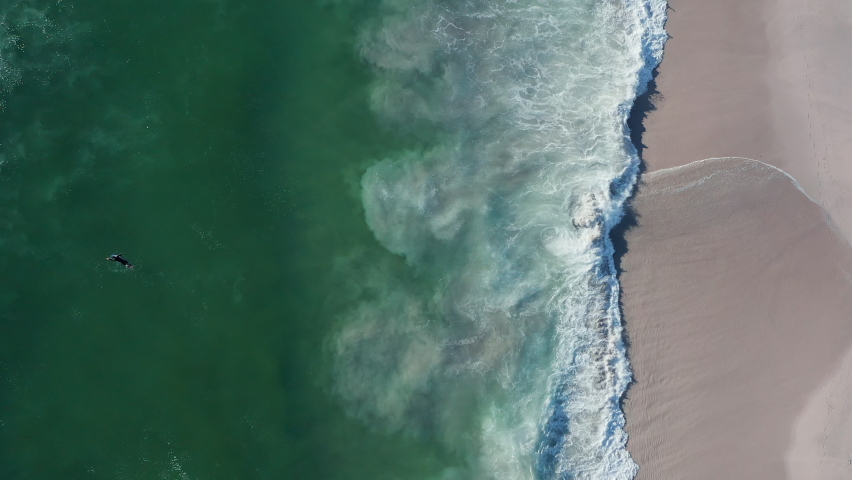 Person Swimming With Surfboard At Blouberg Sea In Cape Town, South Africa. Topdown Shot