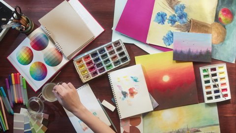 Artist painting with watercolors and brush top view. Art and inspiration, designer. Workspace of creative person using paints, talented human. Leisure and hobby concept.