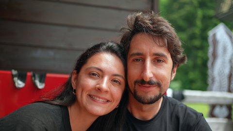A couple posing for camera smiling casual two people looking at camera