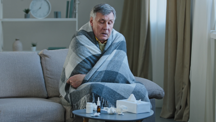 Sick elderly man covered with warm blanket suffer from runny nose sneezes in napkin unwell old grandpa feeling bad fever virus illness symptoms senior male have health problem covid19 epidemic concept Royalty-Free Stock Footage #1088804593