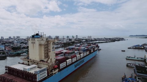 Itajaí, Santa Catarina, Brazil Circa March 2022: Aerial view of a large container freighter heads out to the sea assisted by tugs.