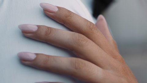 Young wife hand with gentle nude manicure touches shoulder of beloved groom at wedding party closeup slow motion. Happy couple at marriage celebration