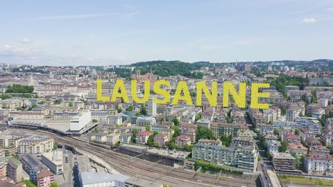 Inscription on video. Lausanne, Switzerland. Flight over the central part of the city. La Cite is a district historical centre. Knitted texture inscription, Aerial View