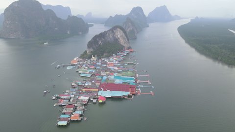 Aerial view fly over Panyee island and village and pass through to Maju island in the back with cloudy sky in area of Phang-ngha, Thailand.