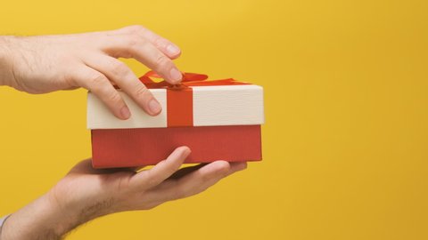 Man holds beautiful gift box on hand and opens the lid. Opening the box. Concept of gift or surprise.