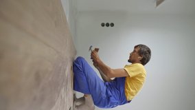 Vertical video. A man professional laminate installer laying laminate wood