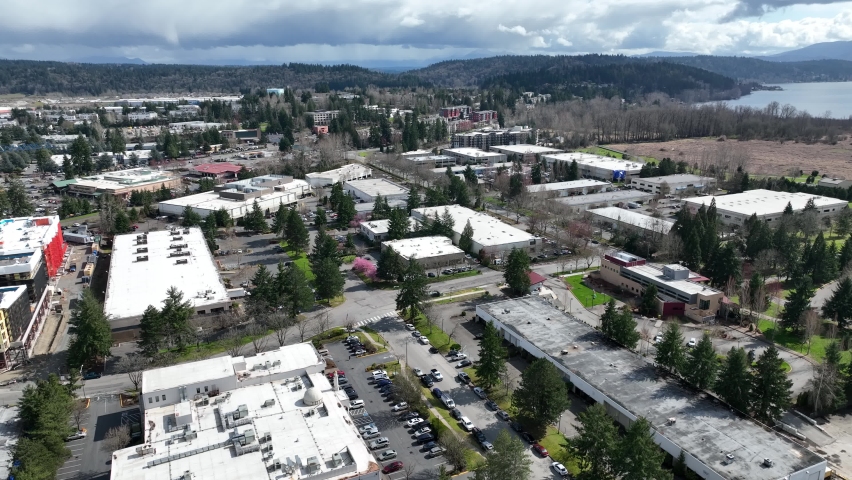 Cinematic 4K aerial drone pan shot of Marymoor Park and Lake Sammamish near Redmond Town Center mall and WA-520, warehouses and businesses in Redmond, Washington