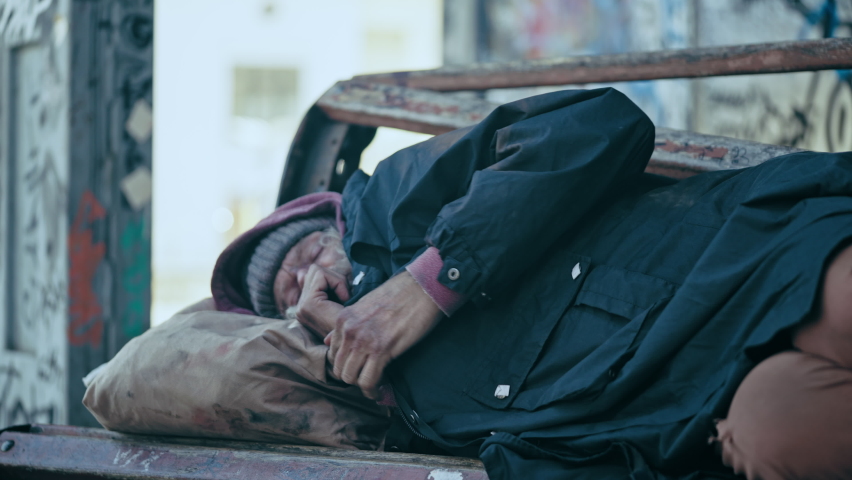Senior homeless man sleeping on bench, trembling from cold, abandonment