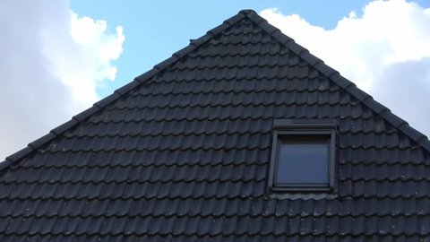 Time lapse of a roof window in velux style with black roof tiles.