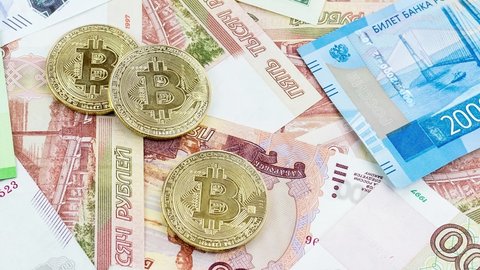 Bitcoin coins (new virtual money) on Russian banknotes A close up image of bitcoins with Russian rubles banknotes Bitcoin coin on the background of Russian rubles Bitcoin Russia Ruble Cryptocurrency