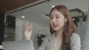 Happy young business woman wearing headphones, Talking and video calling on laptop. Smiling and happy. Soft focus.