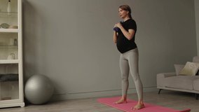 Pregnant female do exercise in living hall at home, body part, lifting dumbbells - Powered by Shutterstock - Get 15% off with code: PIKWIZARD15