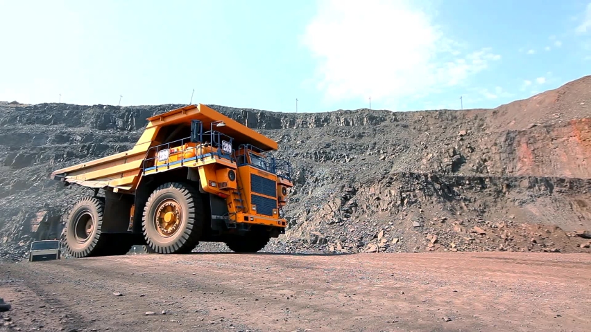 Large mining dump truck. Large dump truck in a coal mine. Yellow dump truck in a coal mine. The dump truck drives through the quarry. | Shutterstock HD Video #1088829763