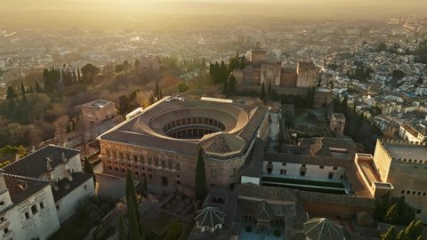 Flying over ancient arabic fortress of Alhambra, Granada, Spain. Aerial sunset view of Alhambra in Andalusia
