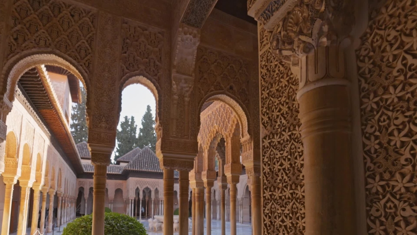 Camera moves between walls and columns with moorish architecture of Court of the Lions, Alhambra, Granada, Andalucia , Spain, Europe. Decorated room and yard in Alhambra, Granada. Gimbal shot, 4K | Shutterstock HD Video #1088830105