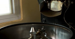 Close up of coffee beans fall in roaster machine process footage 4k video slow motion