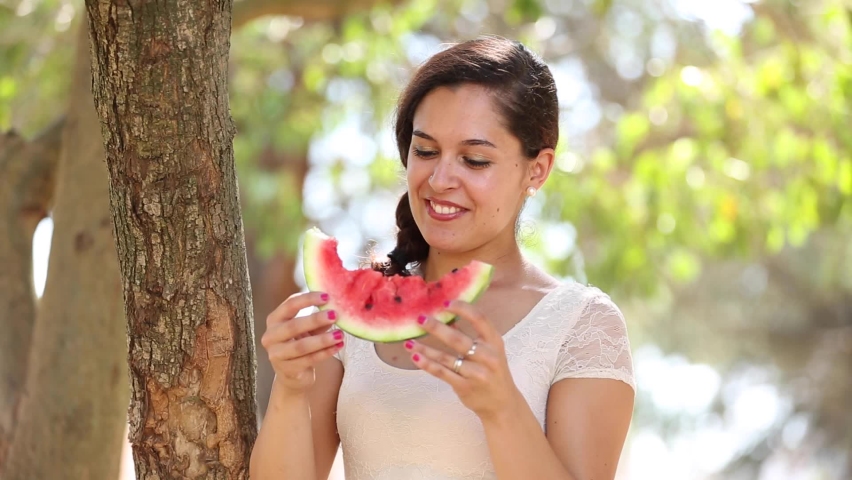 Beautiful young woman eating a slice of watermelon and smiling - Summer and lifestyle concepts in Italy