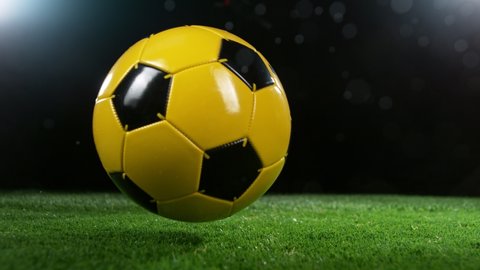 Close-up of Rolling Soccer Ball on Football Field, Rainy Weather. Super Slow Motion at 1000 fps. Filmed on High Speed Cinematic Camera at 1000 fps.