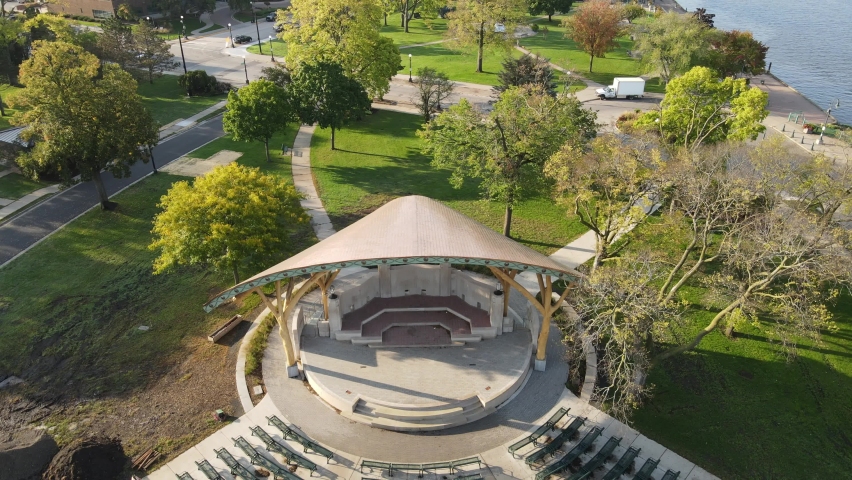 Putting the finishing touches on the new bandshell area in park along Mississippi River in summer. Cement work in progress. Benches in place. Cityscape from drone including big blue bridges. 