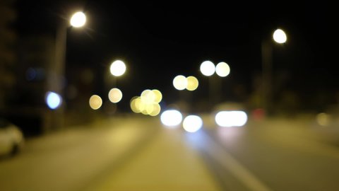 Moving lights of night traffic captured on unfocused camera bokeh