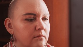 A bald woman in a room at the mirror paints her eyebrows with a brush. Horizontal video