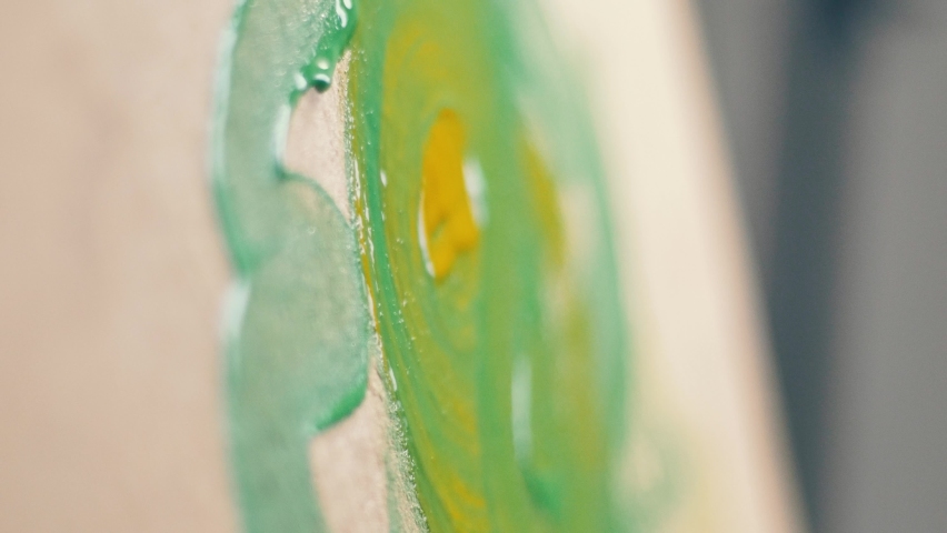 Macro shot of a brush painting drops, streaks of green and yellow acrylic or oil paint on canvas. Royalty-Free Stock Footage #1088843099