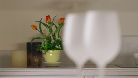 Close-up of two empty wine glasses in the kitchen. White wine glasses. Defocus of flowers in the background on wine glasses in the foreground
