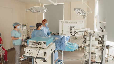 The operation was conducted Professor and assistant. Endoscopic transnasal surgery. Doctors and a nurse are looking at endoscope monitor during surgical operation