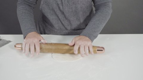 Rolling bread dough with a french rolling pin to make homemade flatbread.