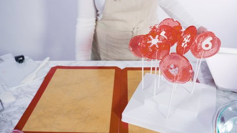 Step by step. Placing homemade lollipops with fondant snowflakes into the lollipop stand.