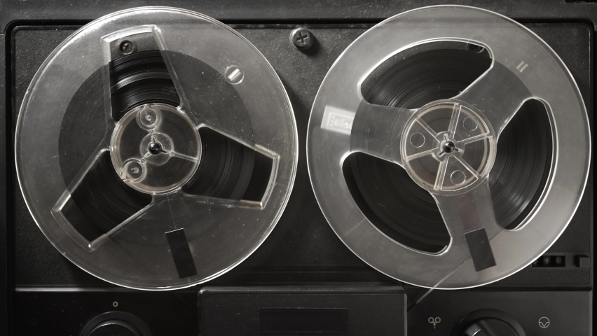 Vintage tape recorder roller. Reel film tape is rotating at a oldschool professional player. Concept of spying and recording a phone conversations Royalty-Free Stock Footage #1088850295