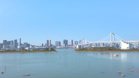 tokyo, japan - october 28 2021: Pan video of a panorama of the bayside of Odaiba with the Rainbow Bridge and the replica of the Statue of Liberty which been offered by France in 1998.