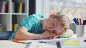 Boy is Doing his Homework at the Table. Cute Child is Learning at Home with the Help of Textbooks and School Materials. Study and Education Concept. - Powered by Shutterstock - Get 15% off with code: PIKWIZARD15