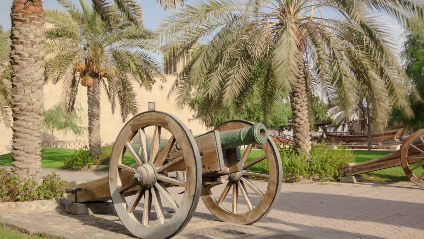 Historic fort at the Museum of Ajman timelapse hyperlapse with blue sky, United Arab Emirates. Old cannon near palm
