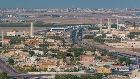 Cityscape of Ajman from rooftop with mosque and traffic timelapse. Villa houses aerial view from above in the United Arab Emirates.
