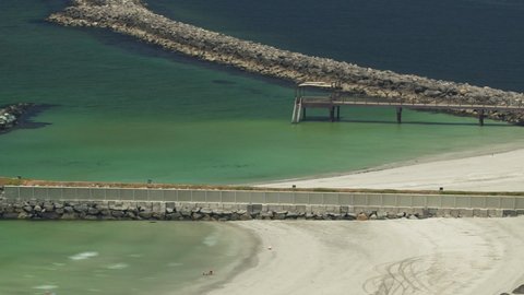 Beautiful area of beach with pier in Ajman timelapse near the turquoise waters of Arabian Gulf, UAE. Panoramic rooftop view of sea shore