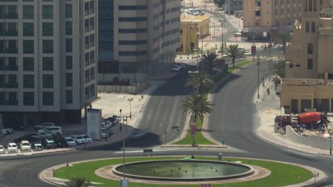 Cityscape of Ajman with circle and traffic on road from rooftop morning after sunrise with long shadows aerial timelapse. Ajman is the capital of the emirate of Ajman in the United Arab Emirates.
