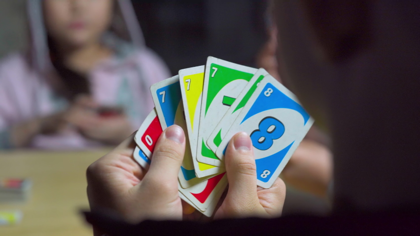 Teens play the card game Uno in the evening in isolation from the pandemic Royalty-Free Stock Footage #1088858207