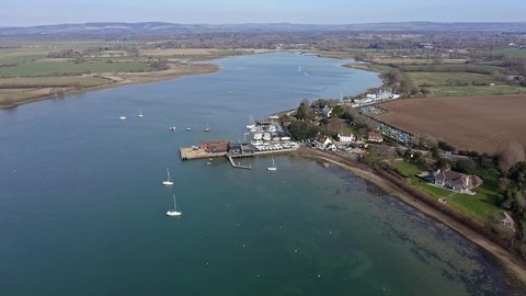 Aerial footage of Dell Quay in Chichester Harbour Estuary England with Sailing Boats and Sailing Dinghies.